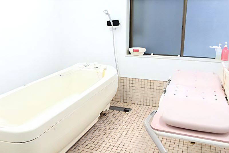清潔で広々とした個別浴槽と介助用ベッドの様子
