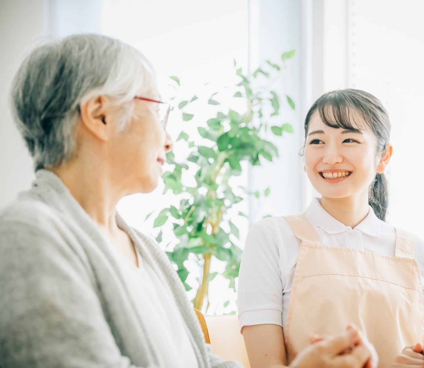 自宅で看護師と笑顔で話す高齢女性のご利用者様